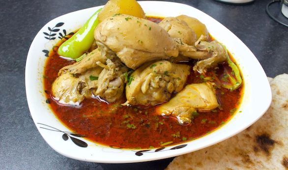 A bowl of Lahori Aloo Chicken Shorba, showcasing tender chicken, potatoes, and aromatic spices.